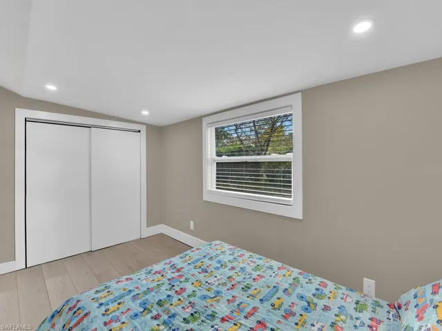 Bedroom featuring recessed lighting, light wood-type flooring, and a closet