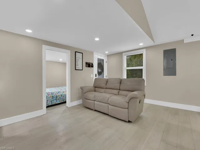 Living area featuring electric panel, light wood-style flooring, and recessed lighting