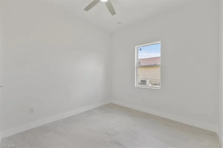 Unfurnished room featuring baseboards and ceiling fan
