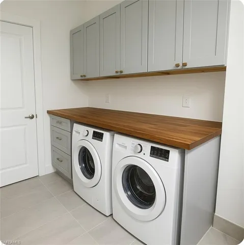 Laundry room featuring, cabinet space, and light tile patterned floors