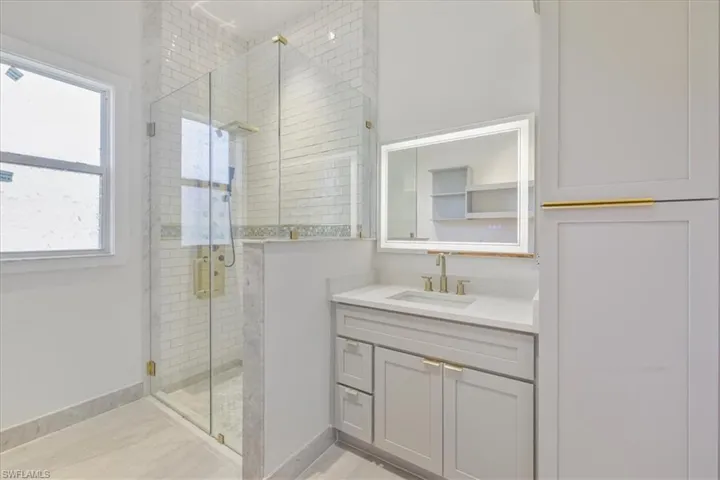 Full bath featuring a stall shower and vanity