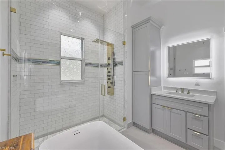 Master Bathroom with a shower stall, vanity, and a bath