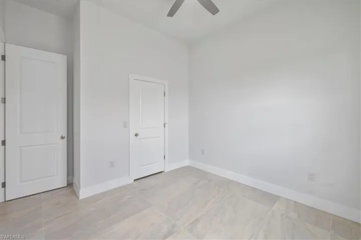 Unfurnished bedroom with a ceiling fan and light marble finish flooring