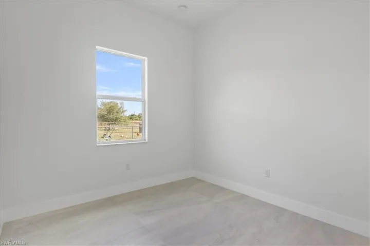 Empty room featuring baseboards and a smoke detector