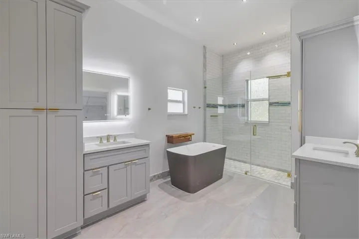 Master Full bath with two vanities, a stall shower, a soaking tub, and recessed lighting