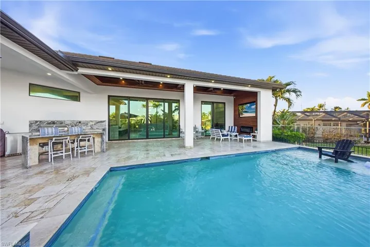 View of pool featuring patio surround and exterior kitchen