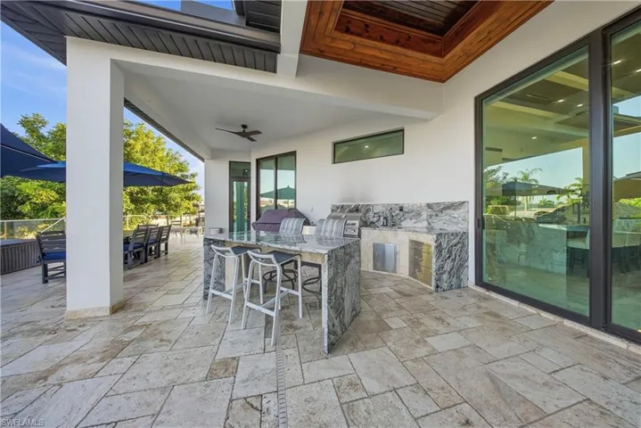 View of patio / terrace featuring area for grilling, an outdoor bar and dining area, and a ceiling fan