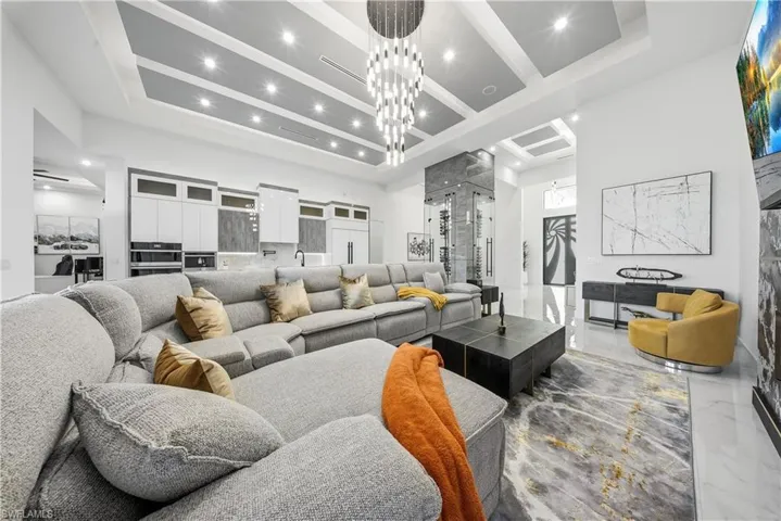 Living area featuring chandelier, and coffered ceiling