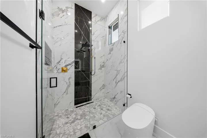 Bathroom featuring a marble finish shower and marble finish floors