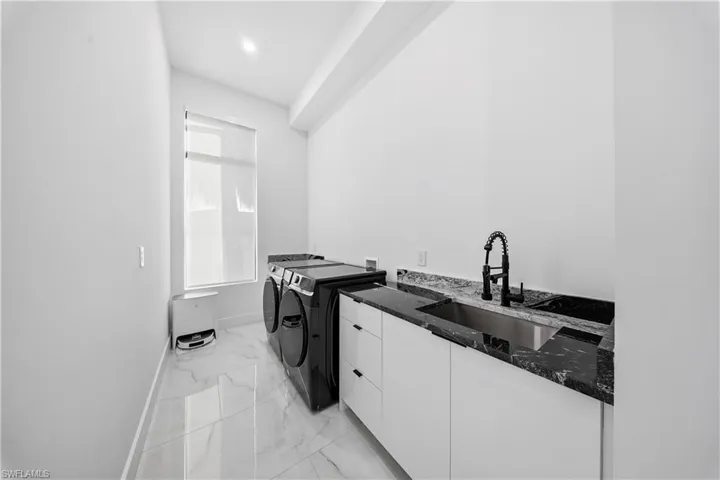 Laundry room with cabinet space, washing machine and dryer, and recessed lighting