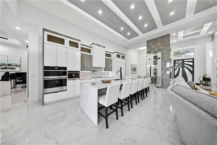 Kitchen featuring modern cabinets, white cabinets, glass insert cabinets, double oven, and open floor plan