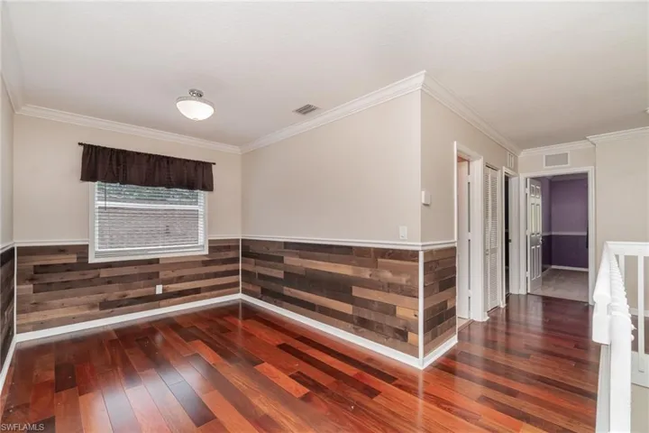 Spare room featuring crown molding and hardwood / wood-style floors