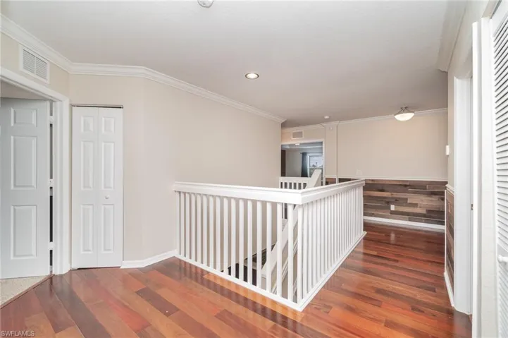 Corridor featuring hardwood / wood-style flooring and crown molding