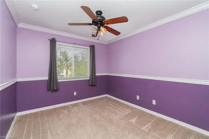 Carpeted spare room with ornamental molding and ceiling fan