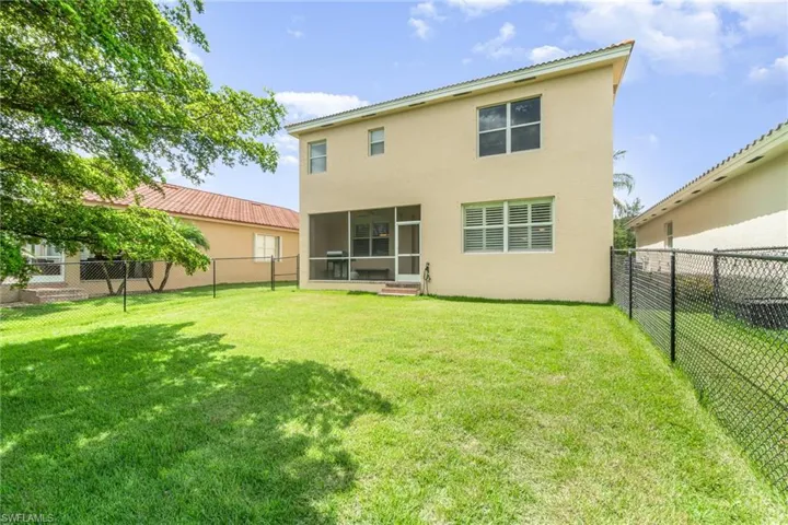Rear view of property with a lawn