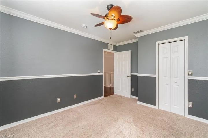 Unfurnished bedroom featuring crown molding, carpet, and ceiling fan