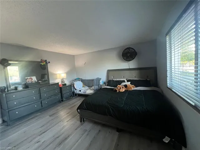 Bedroom featuring wood finished floors and a textured ceiling