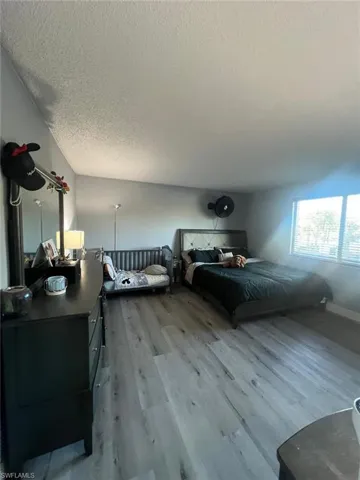 Bedroom featuring a textured ceiling and wood finished floors