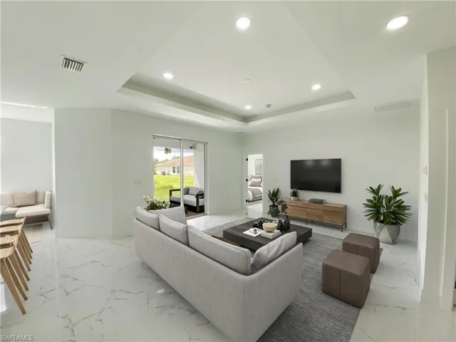 Virtually staged Living room featuring a tray ceiling and light tile patterned flooring