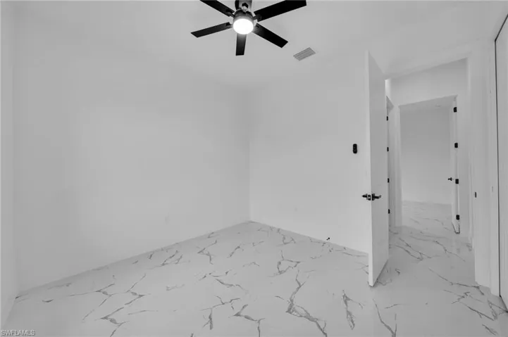 Unfurnished room with marble finish flooring and ceiling fan