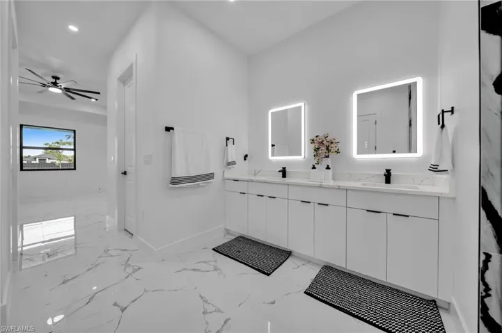 Full bathroom featuring double vanity, marble finish floors, recessed lighting, and a ceiling fan