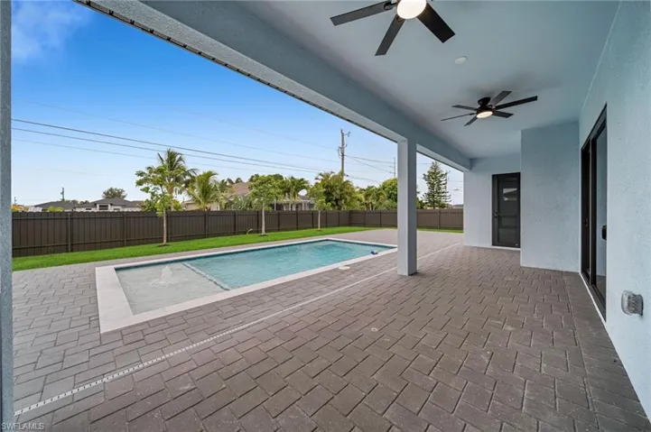 View of pool featuring ceiling fan, a fenced backyard, and a patio