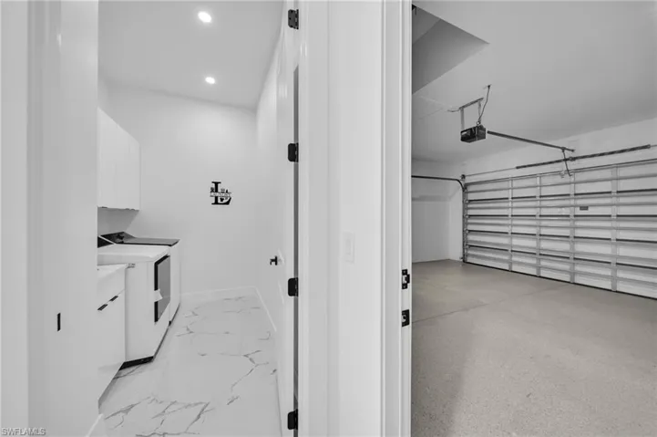 Washroom with recessed lighting, washer / dryer, and a garage