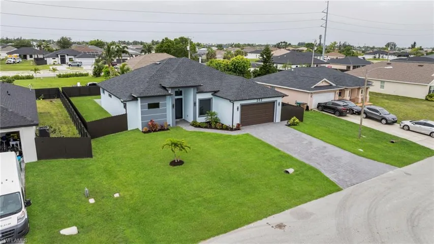 View of front of home with a residential view, decorative driveway, a garage, roof with shingles, and stucco siding