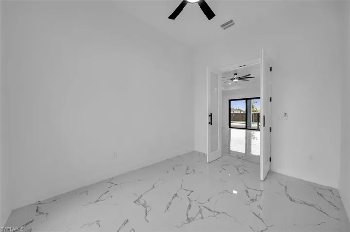 Foyer entrance featuring a ceiling fan and light marble finish flooring
