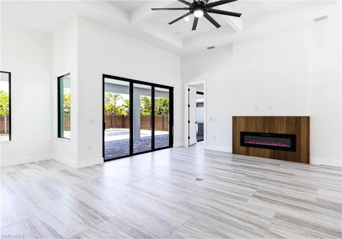 Great room concept with coffered ceiling, ceiling fan, recessed lights and 24 x 48 Porcelain rectified tile.