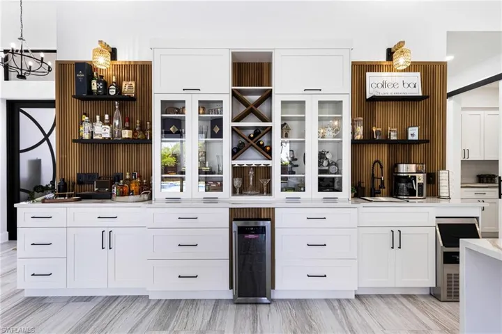 HONEY..... WE FOUND OUR NEW HOME! Custom Ash wood Wet Bar/Cigar Bar/Coffee Bar. Featuring wine cooler, ice machine, sink, recessed and decorative light fixtures.