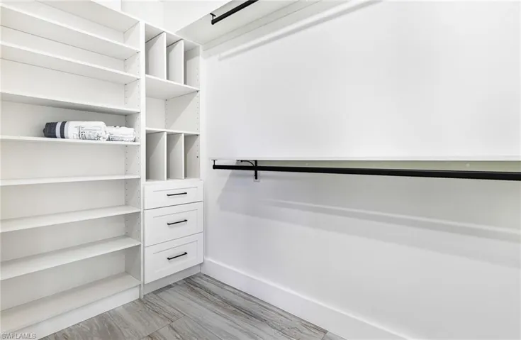 Her walk in closet with custom shelving to store shoes, handbags and lots of space for hanging your wardrobe.