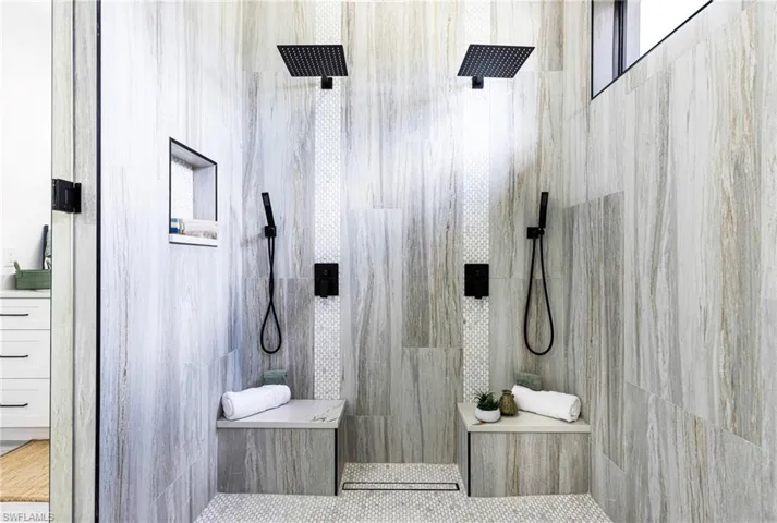 Primary dual shower. No more fighting over the water temp. Custom tile work, niche and benches. Wands to make cleaning easier.