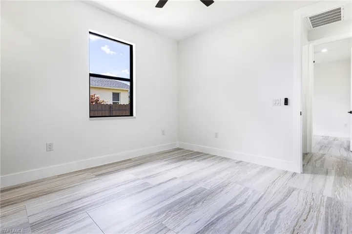 Guest bedroom with high ceilings, and ceiling fan with remote.