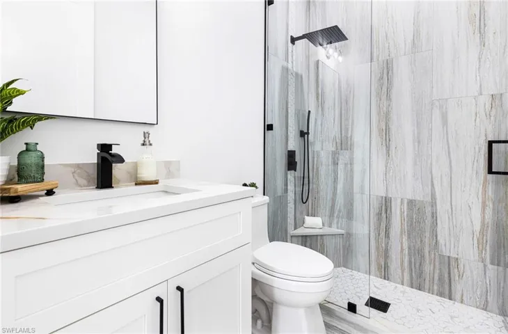 Guest Bathroom featuring upgraded walk in tile shower with glass doors. Custom Niche and bench.