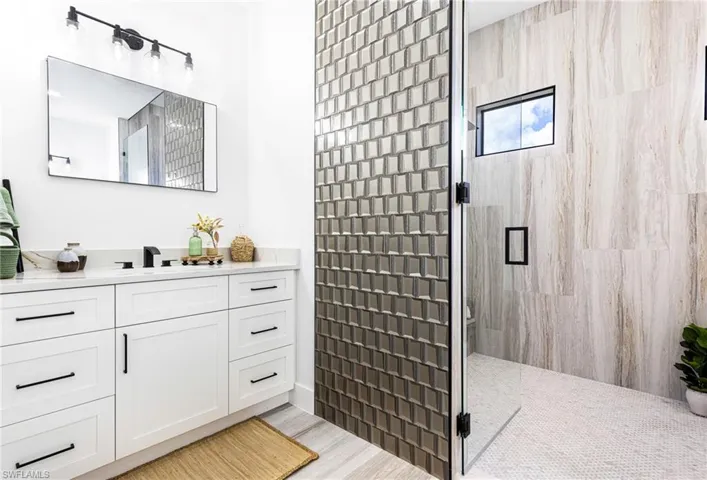 Primary Bathroom featuring white shaker styled vanities.