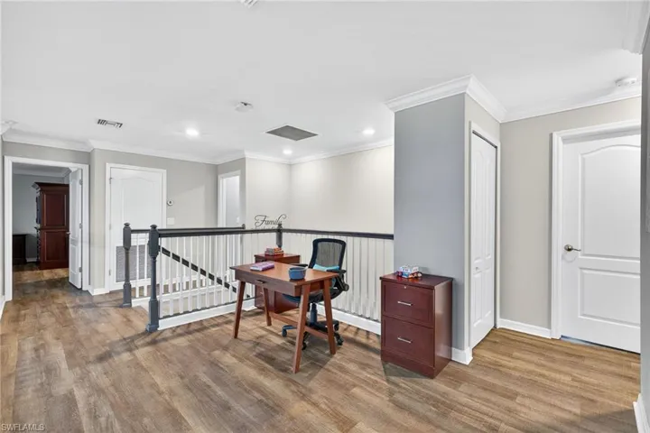 Office space with ornamental molding, light wood-style floors, and recessed lighting