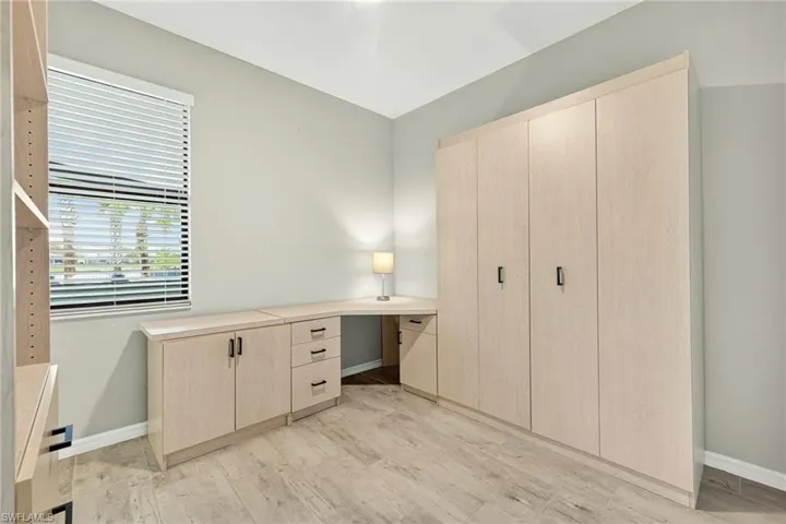 Unfurnished bedroom featuring light wood-type flooring and built in desk