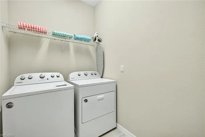 Laundry room featuring washer and clothes dryer and baseboards