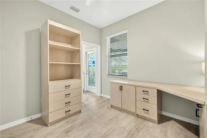 Unfurnished office featuring wood tiled floors and built in desk