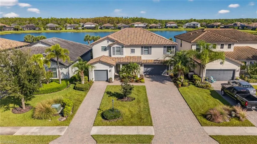 Mediterranean / spanish house with a residential view, decorative driveway, a garage, and a water view