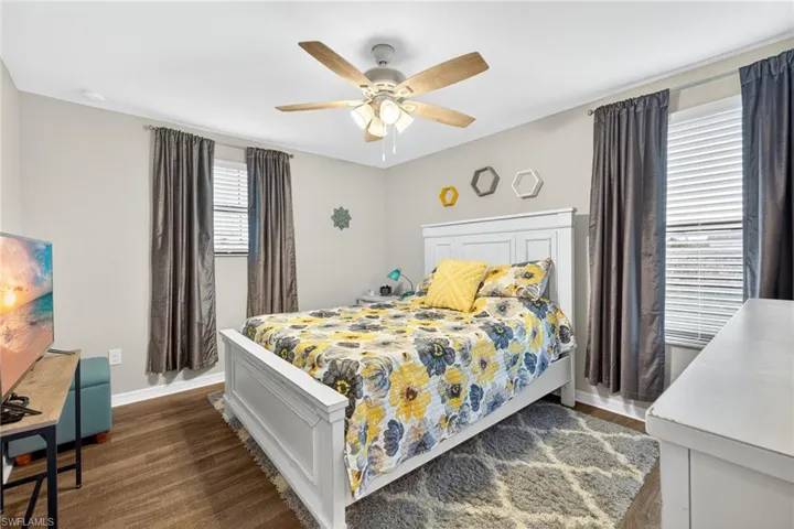 Bedroom with dark wood-style floors and a ceiling fan