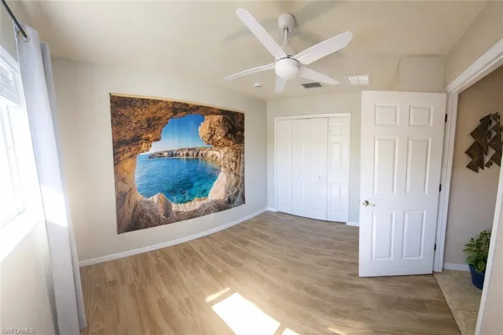 Unfurnished bedroom featuring light wood-style floors, a ceiling fan, and a closet