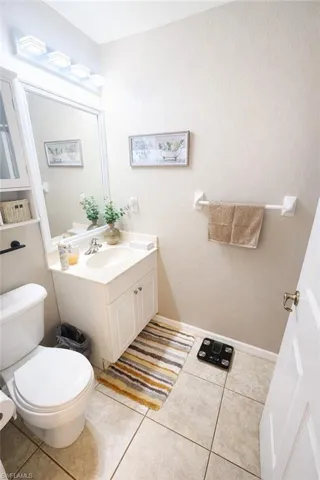 Half bath with vanity, light tile patterned floors, and a textured wall
