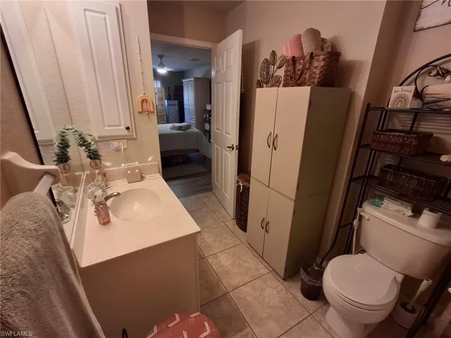 Bathroom featuring vanity, light tile patterned floors, connected bathroom, and a ceiling fan