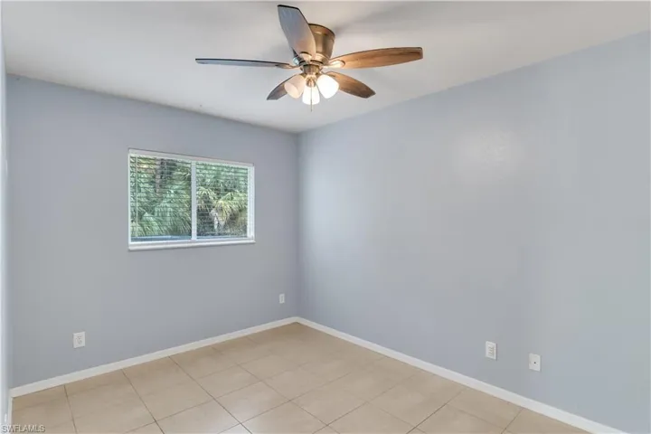 Tiled spare room with ceiling fan