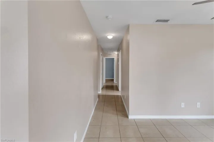 Corridor featuring light tile patterned floors