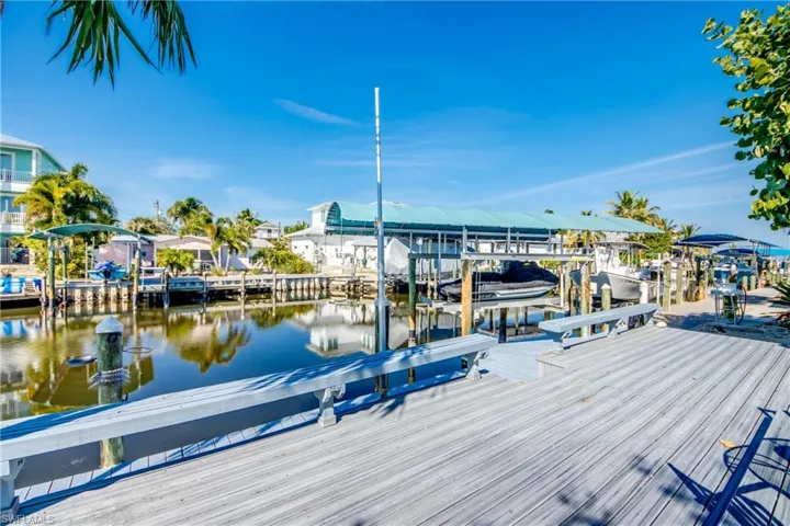 Dock with boat lift, a water view, and a residential view