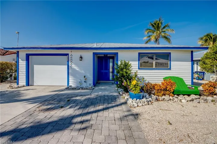 View of front of home featuring decorative driveway, a garage, and a metal roof