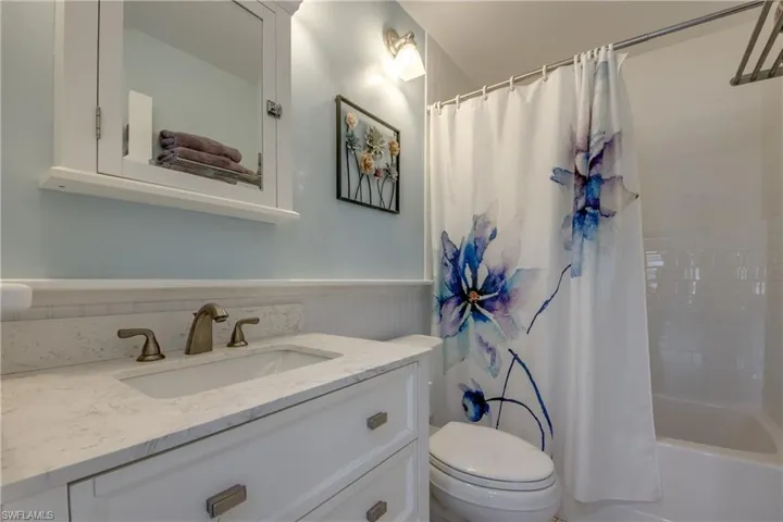 Bathroom with vanity and shower / bath combo with shower curtain